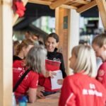 Fünf Frauen in Sportkleidung bei der Startnummernausgabe